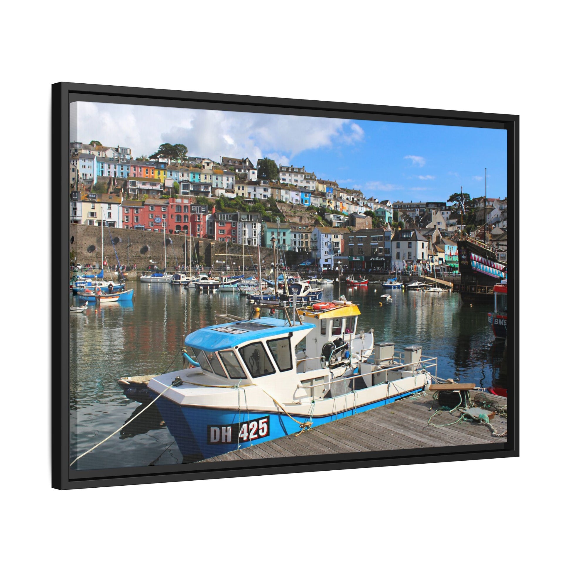 Framed photograph of a harbour scene with boats and colourful buildings.