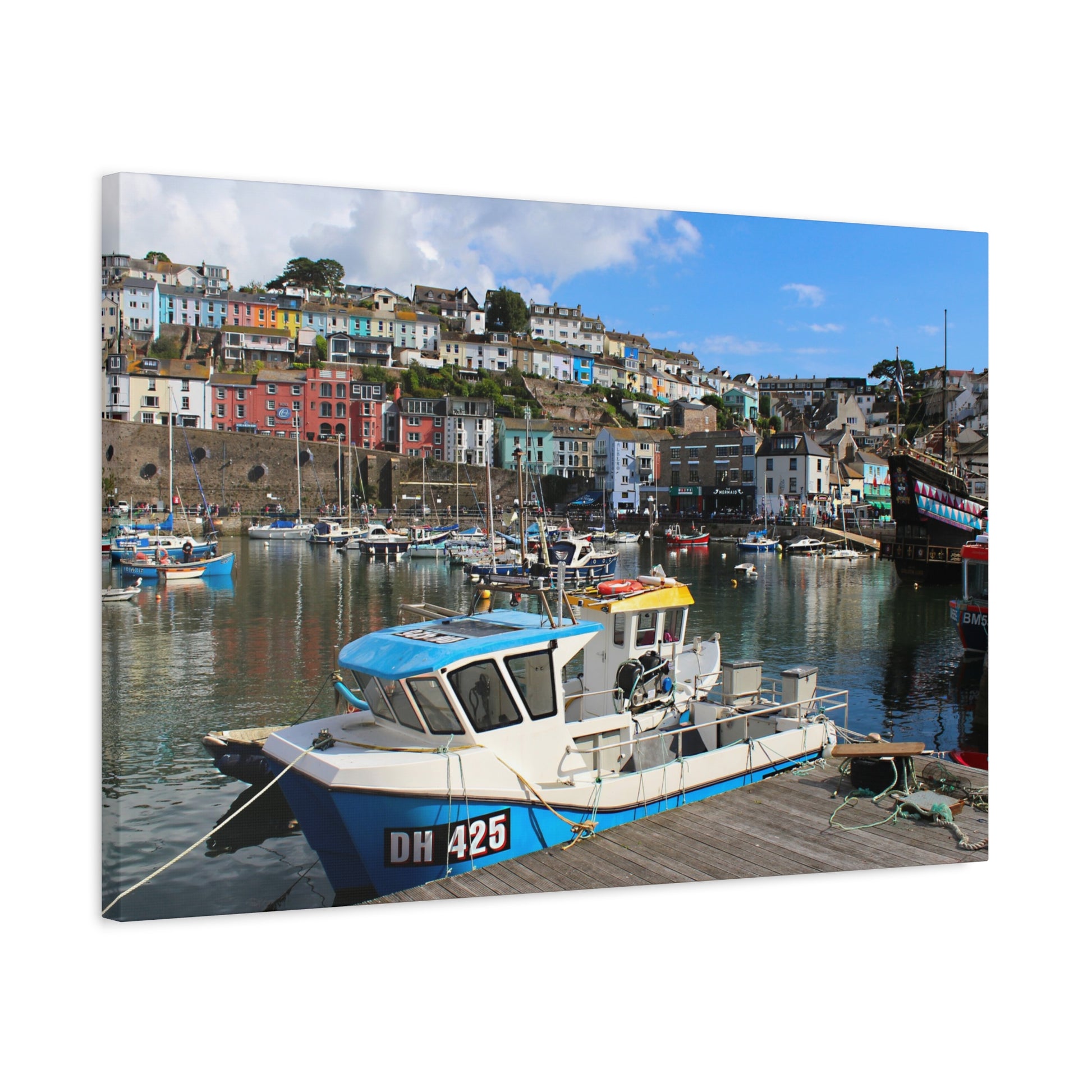 Boat docked at a harbour with colourful houses in the background