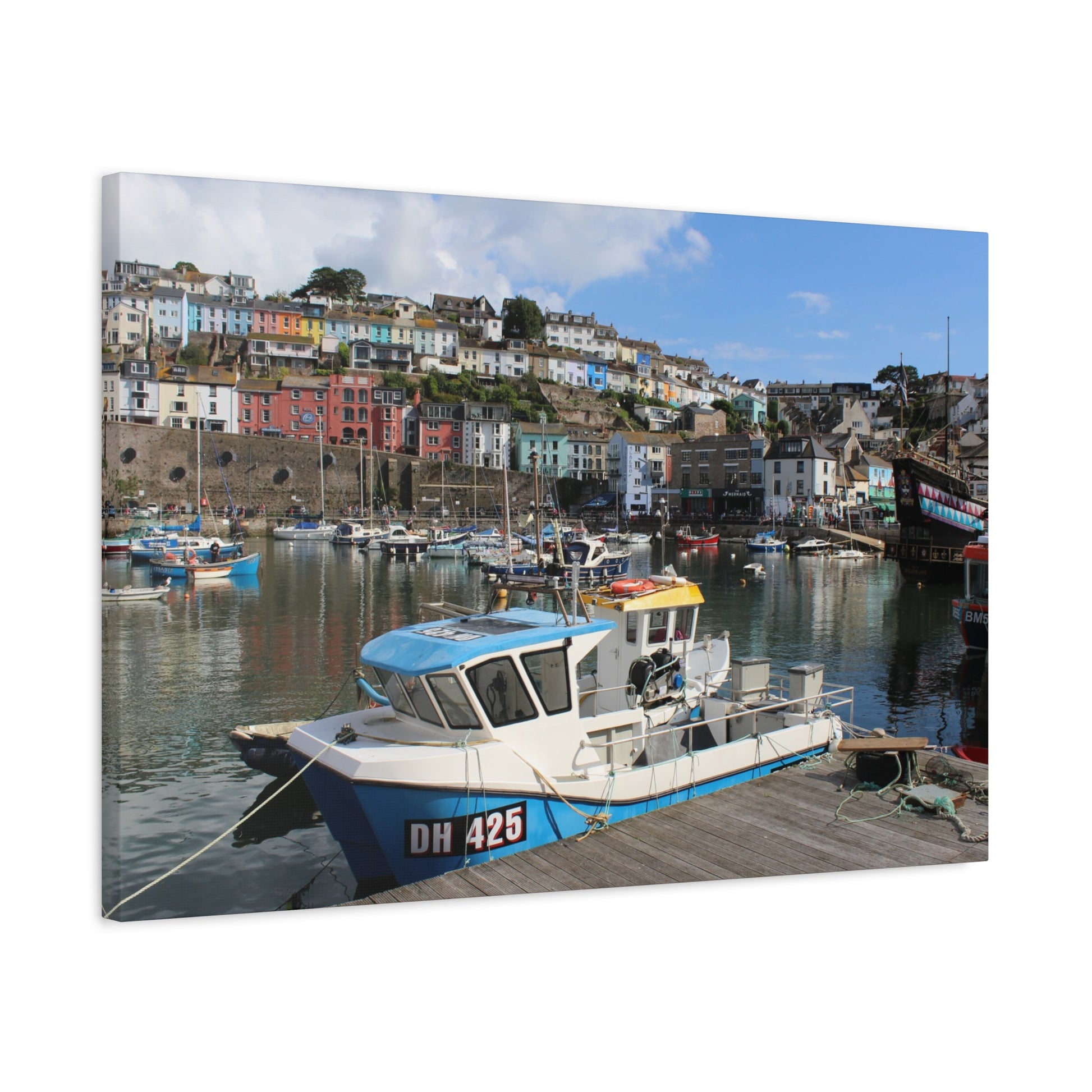 Boat docked at a harbour with colourful houses in the background