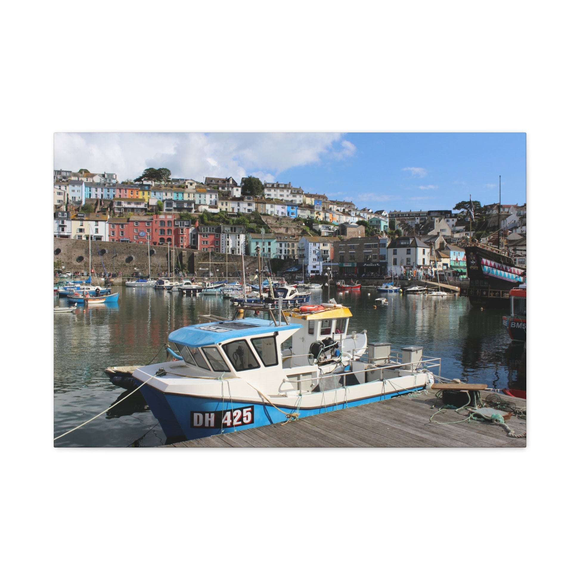 Boat docked at a harbour with colourful buildings in the background