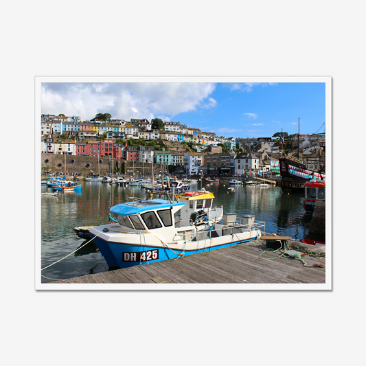 Framed photograph of a harbour scene with boats and colourful buildings.