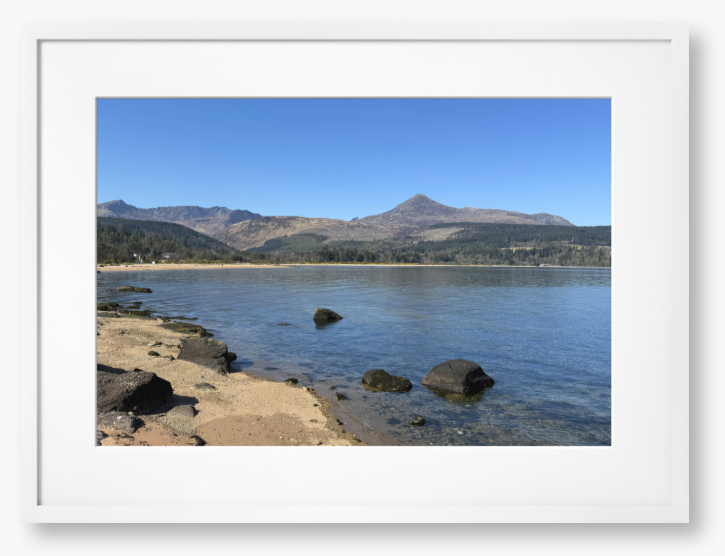 A framed photo of Brodick Bay on the Isle of Arran, showing the beach and mountains in the background with a clear blue sky.