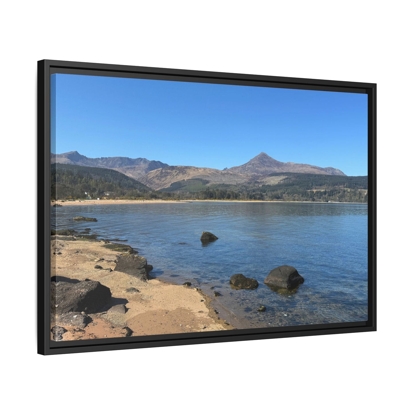 Framed picture of a scenic view with mountains and a lake.