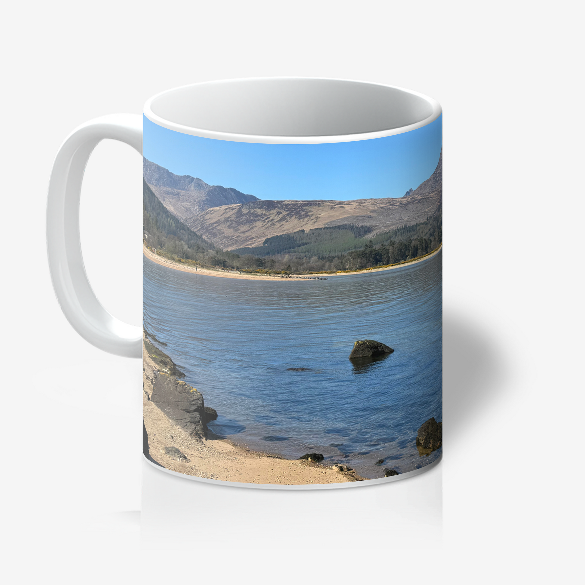 Mug with a scenic design of a lake and mountains on a white background