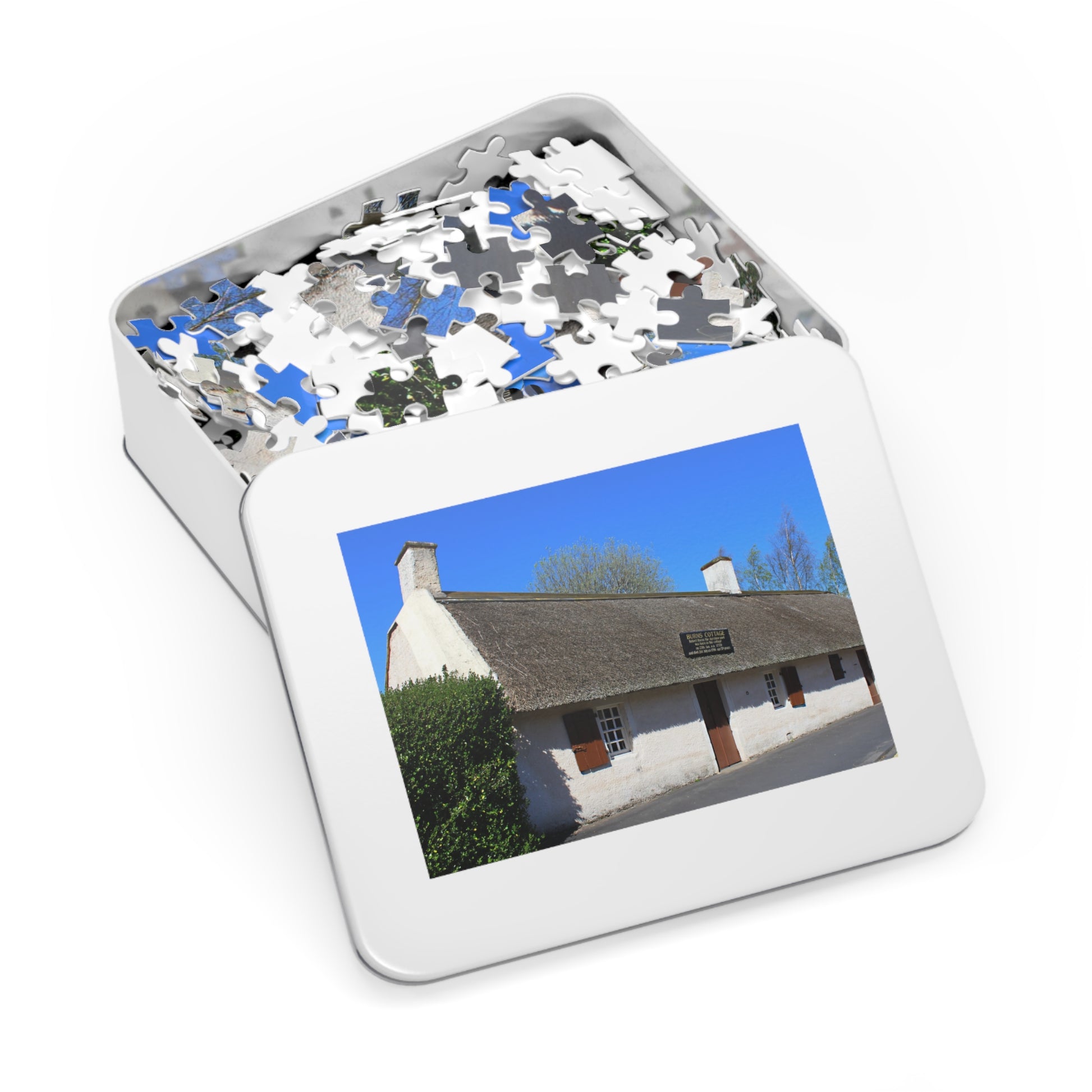 Jigsaw puzzle in a tin with a picture of a house on the lid