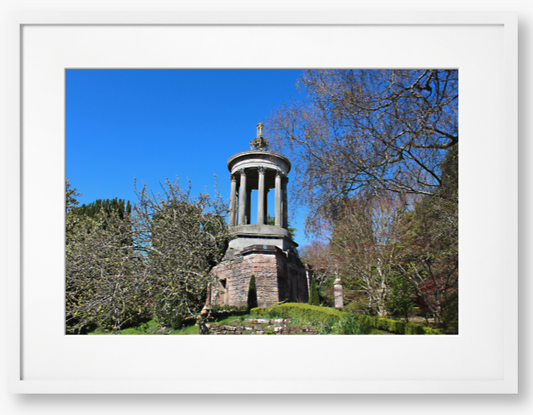 Framed Photo Of A Stone monument in a park with trees and blue sky