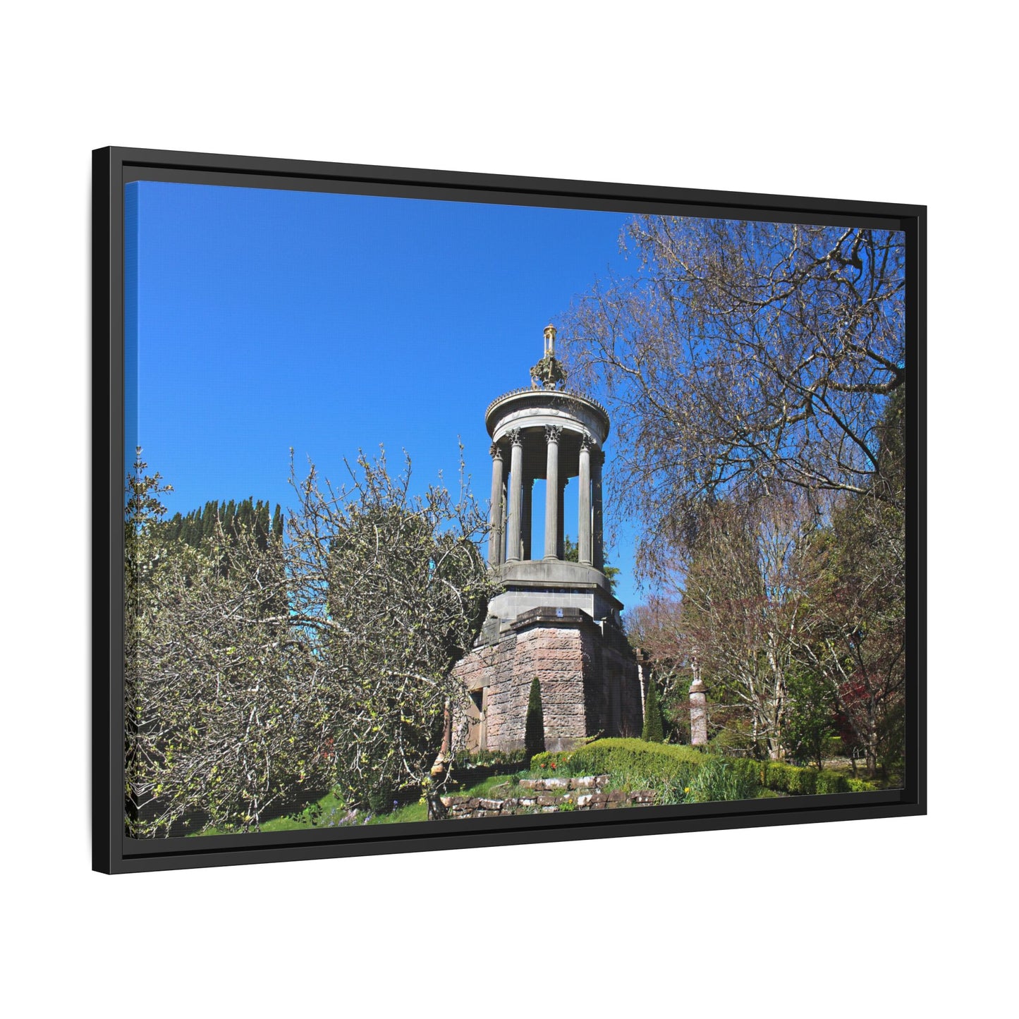 Stone monument in a park with trees and blue sky