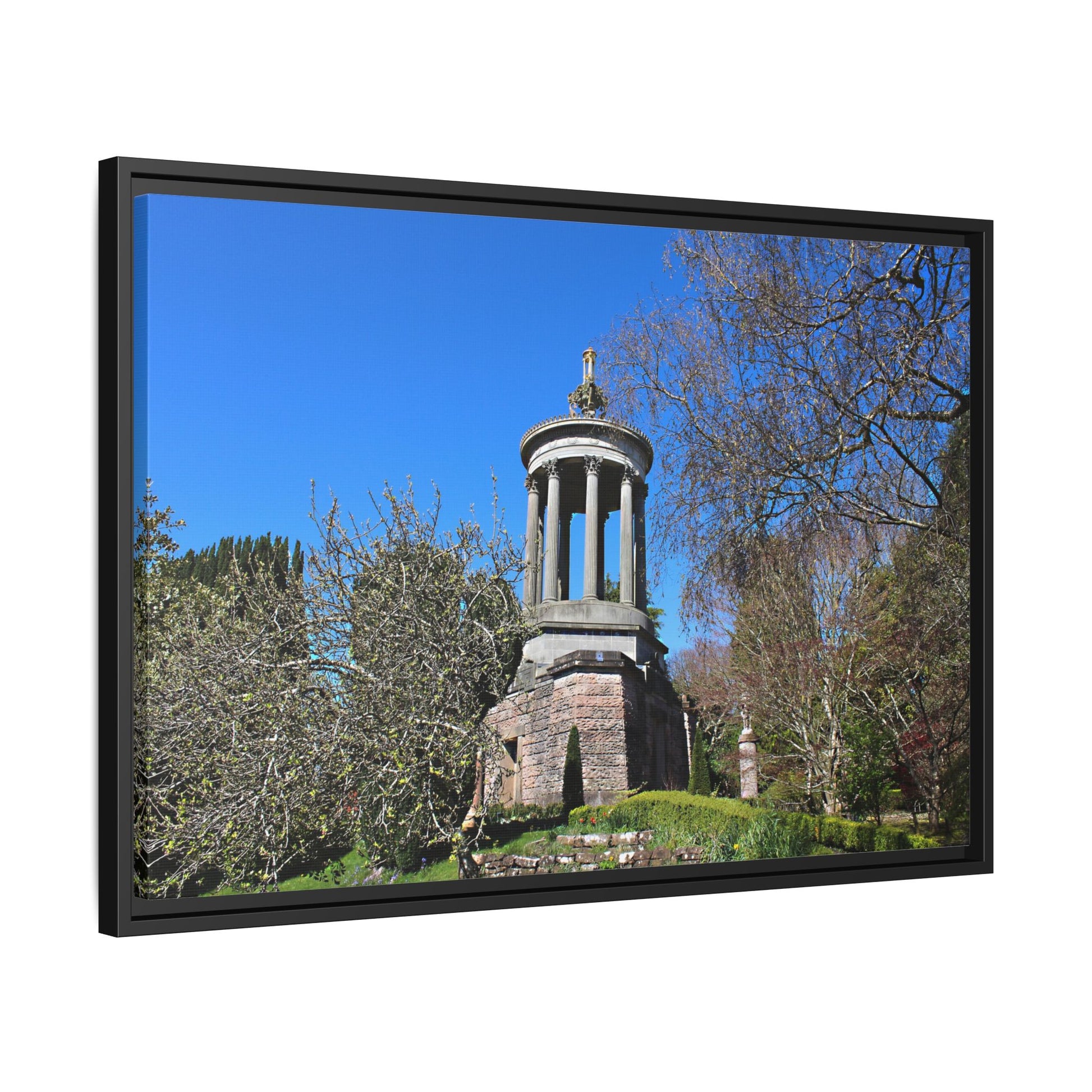 Stone monument in a park with trees and blue sky