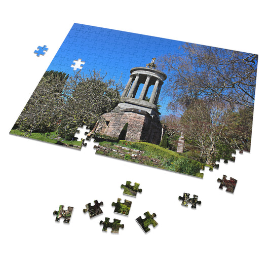 Jigsaw puzzle of a scenic landscape with trees and a stone monument on a white background