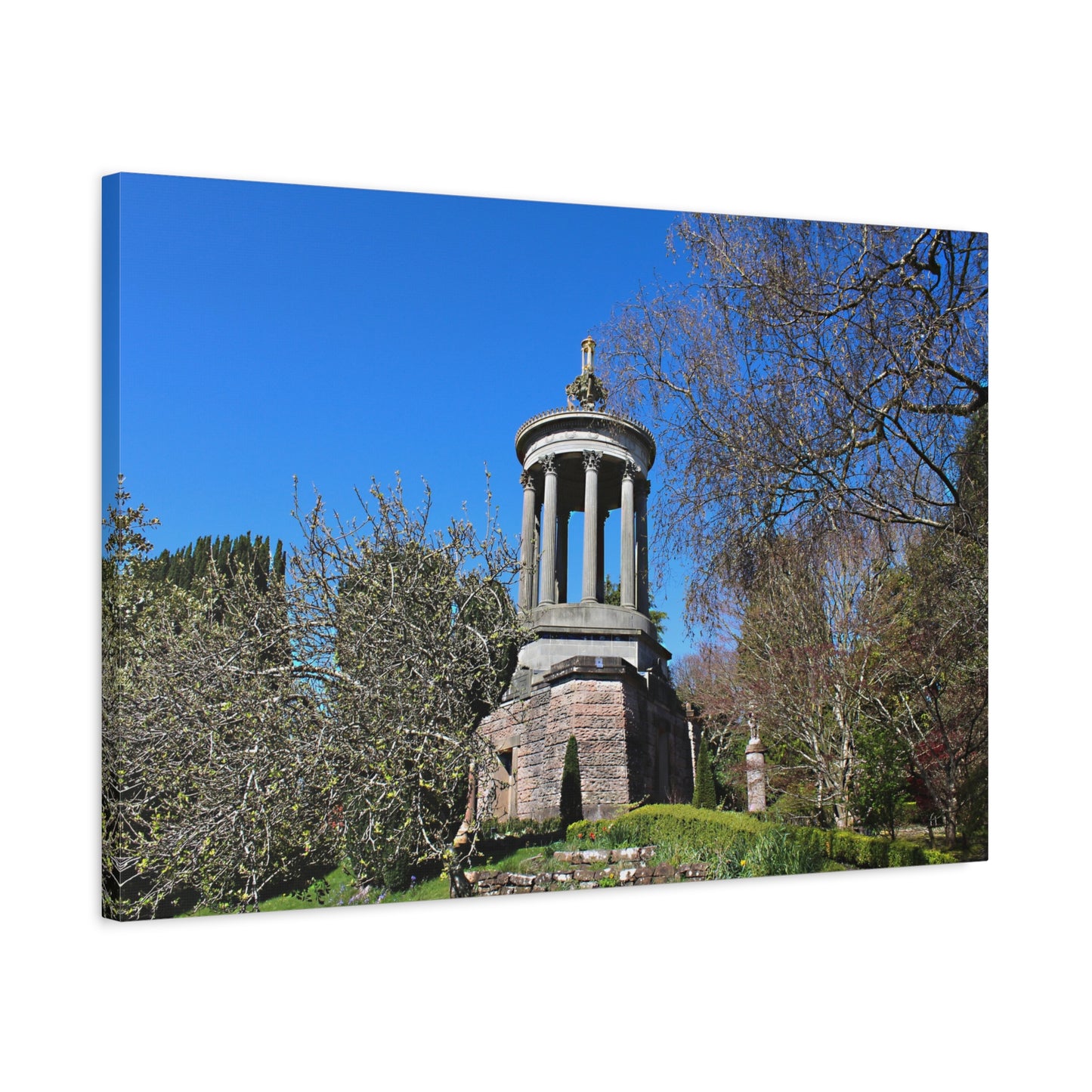 Stone monument in a park with trees and blue sky