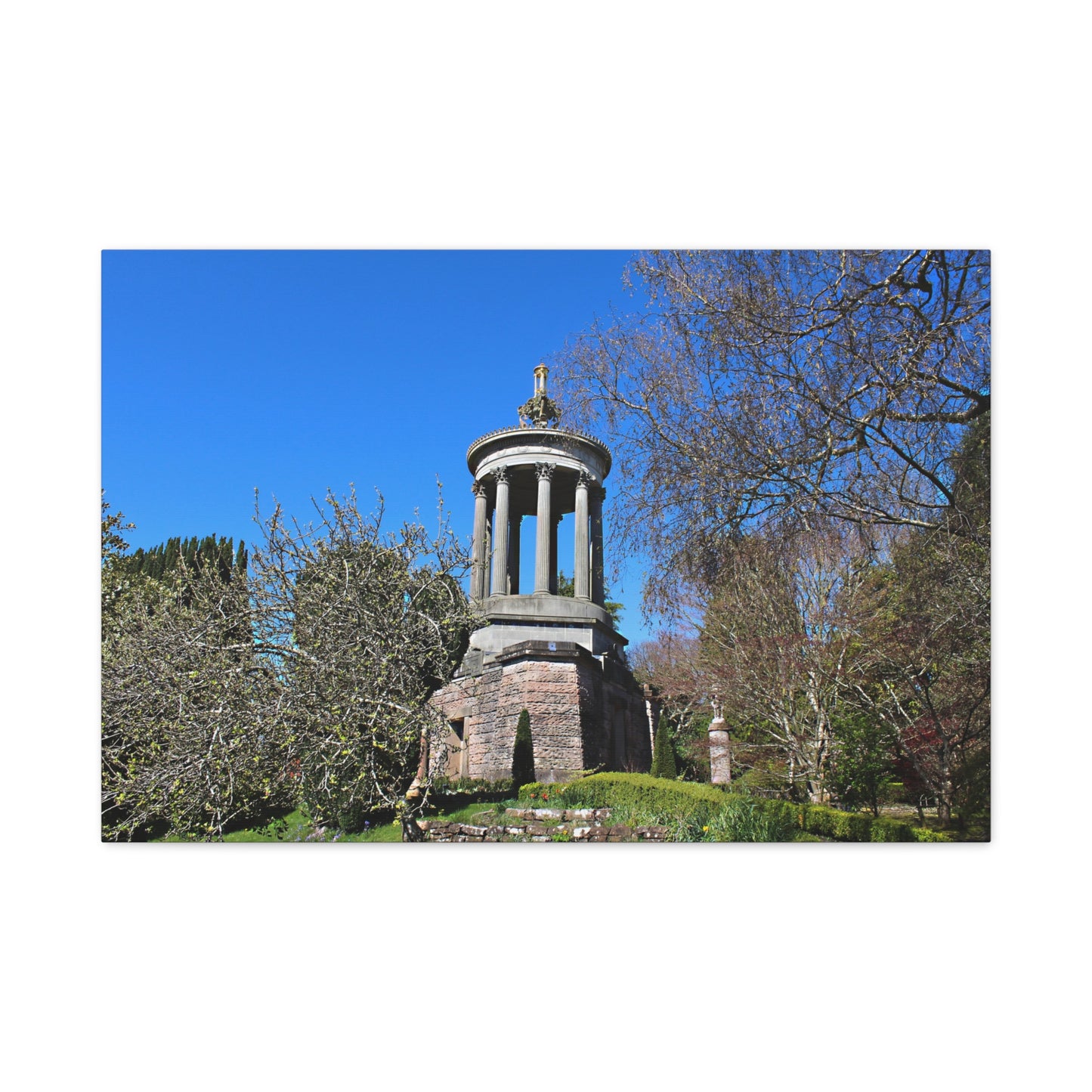Stone monument in a park with trees and blue sky
