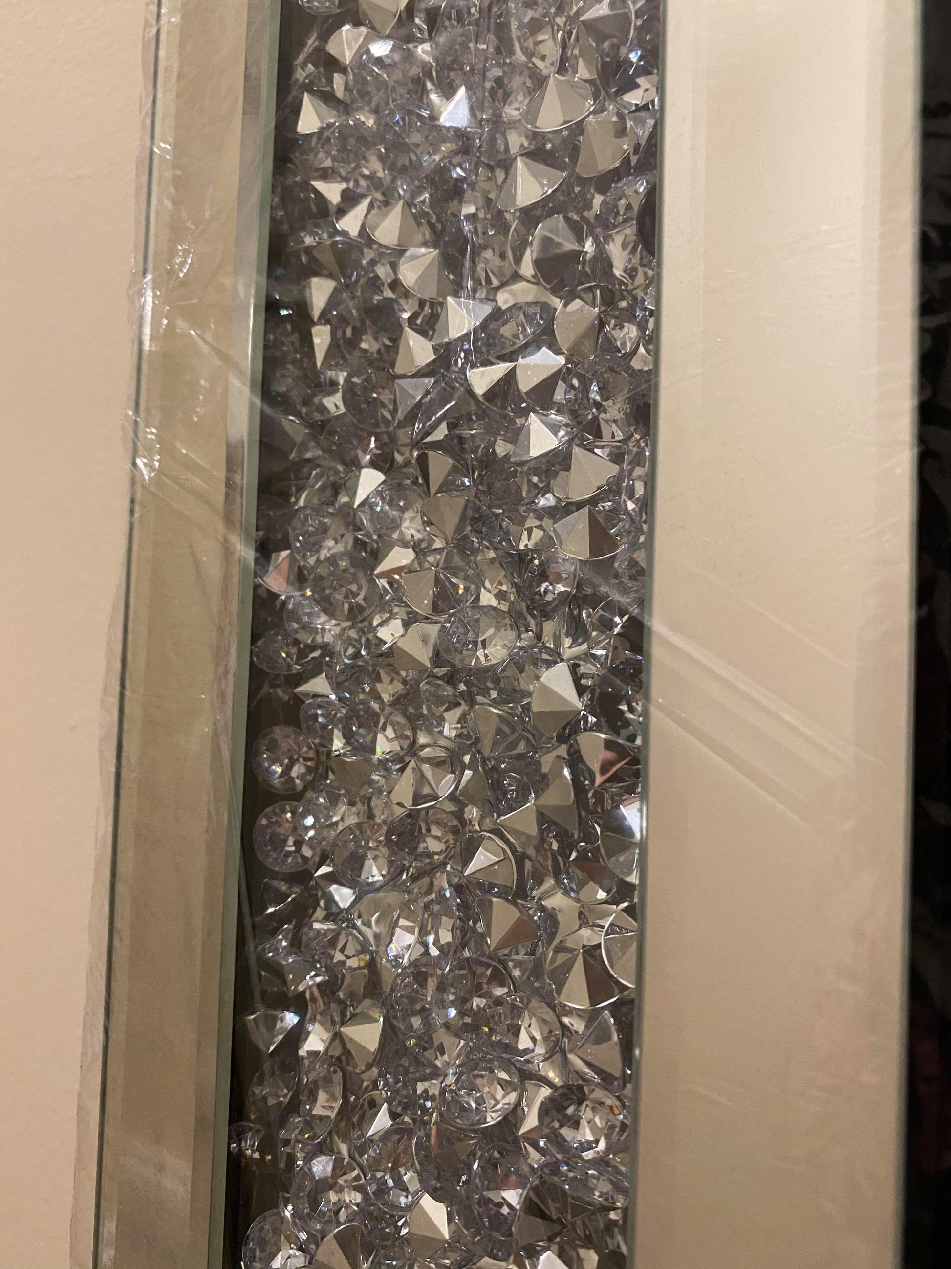 Frame of a bevelled wall mirror with crushed crystals.