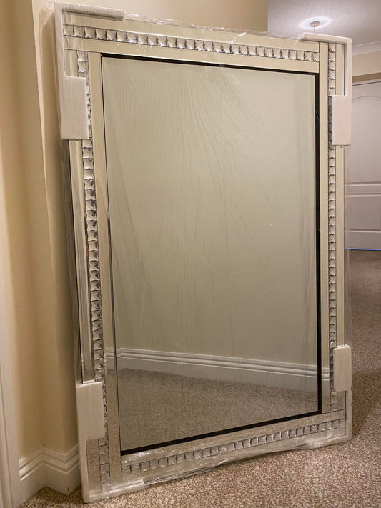 Bevelled edge wall mirror with a diamante frame.