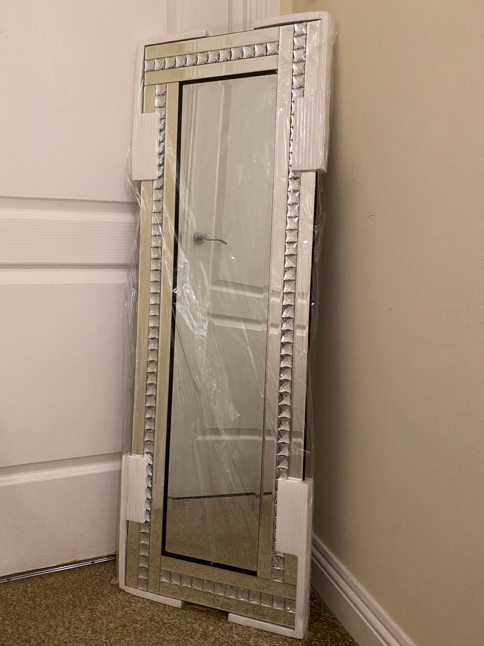 Bevelled edge wall mirror with a diamante frame.