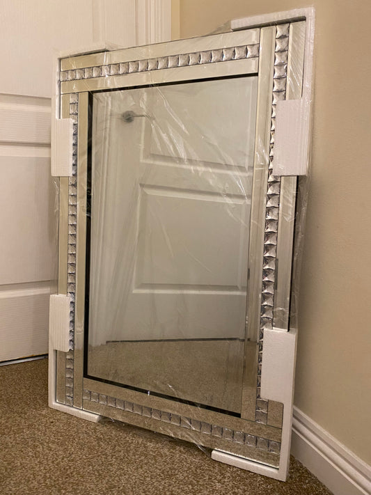 Bevelled edge wall mirror with a diamante frame.