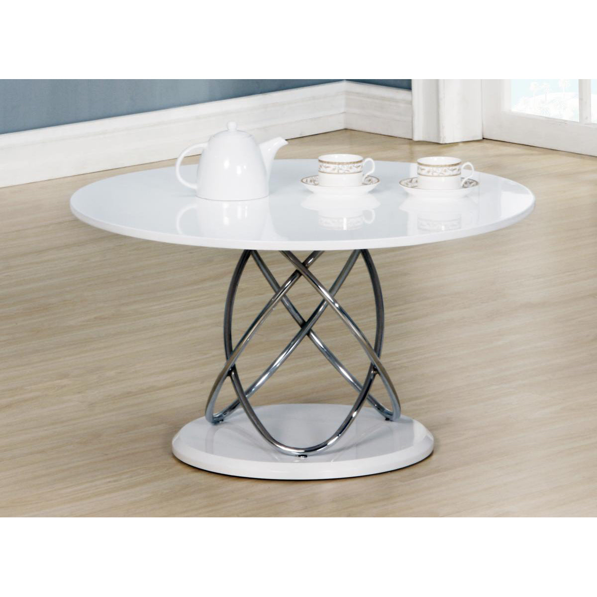 Round white high gloss coffee table with a chrome base on a wooden floor.