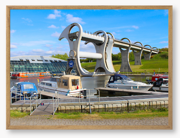 A framed photo of the Falkirk Wheel boat lift with boats docked at a marina under a blue sky.