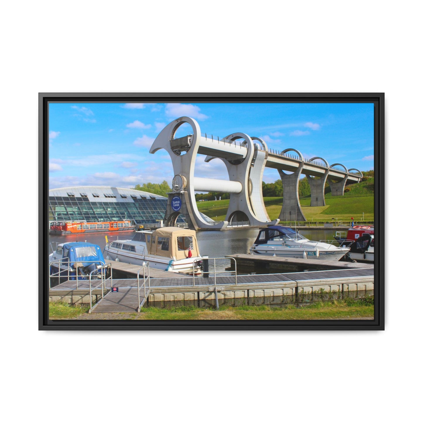 Falkirk Wheel boat lift with boats docked below on a clear day