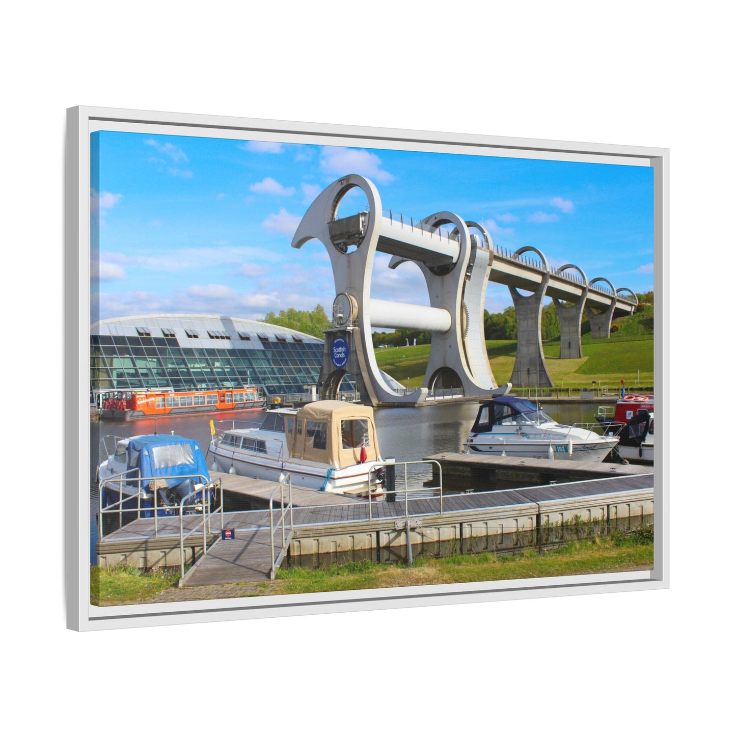 Falkirk Wheel boat lift with boats docked at a marina on a sunny day.