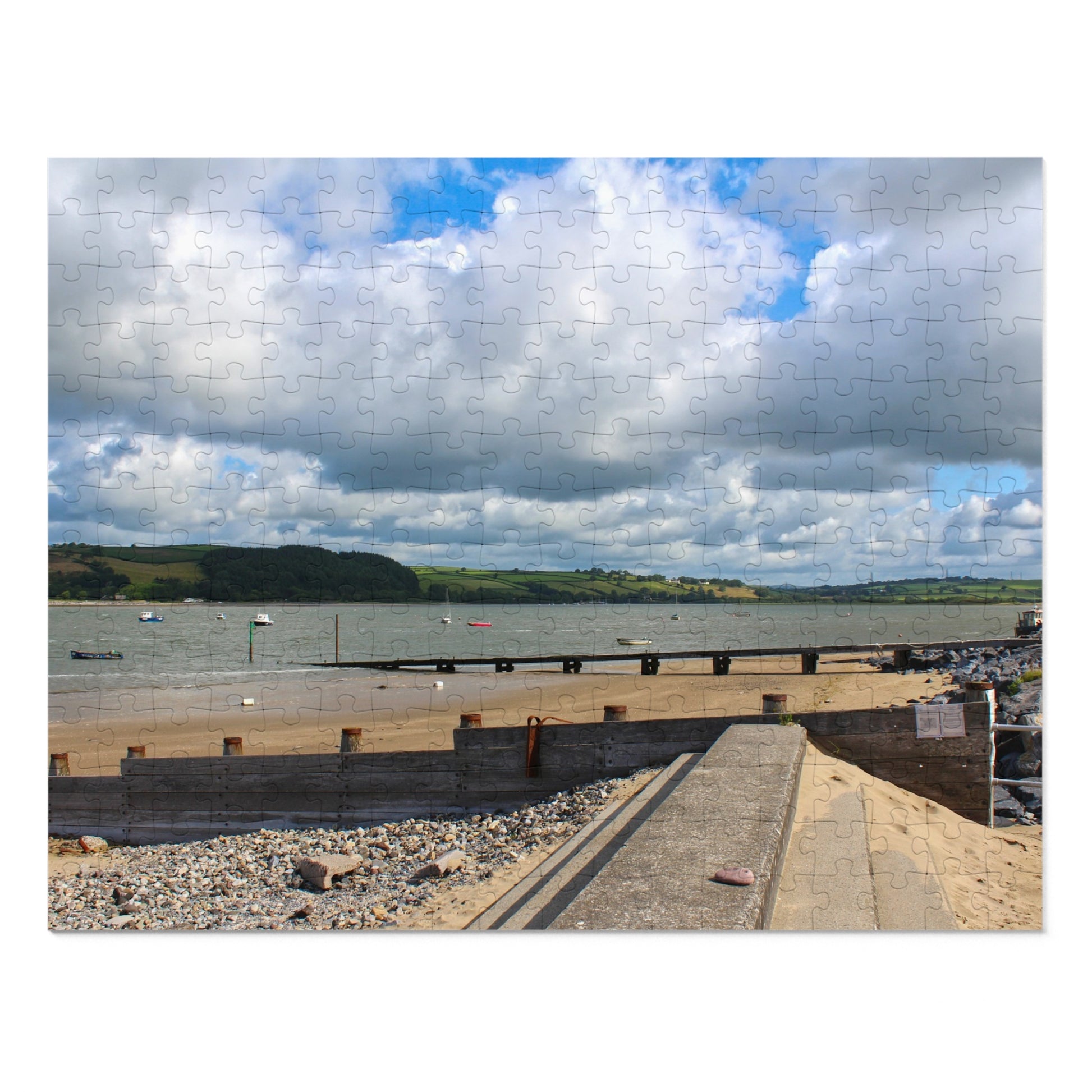 Paved pathway leading to a waterfront with boats and a cloudy sky.