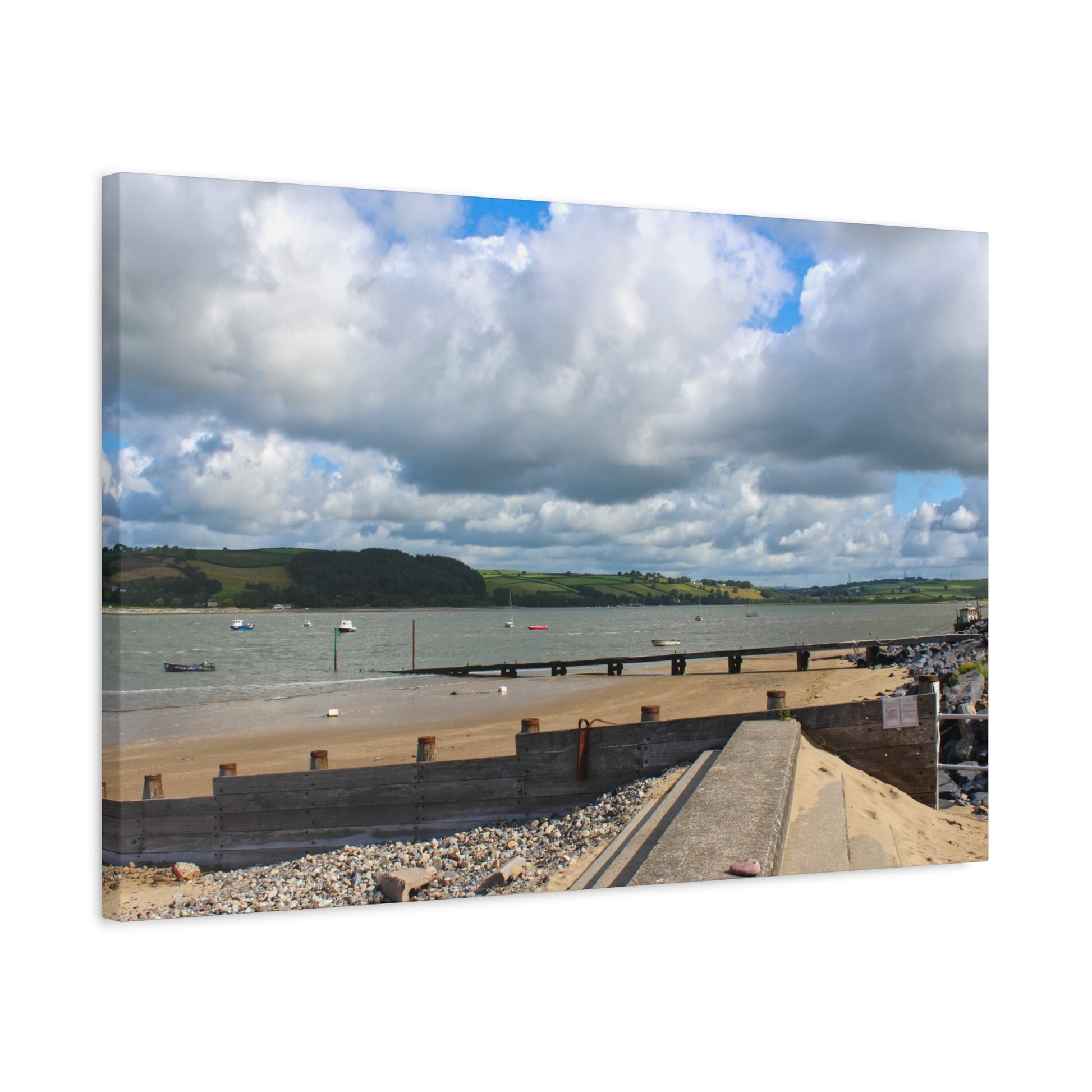 Panoramic view of a coastal scene with a road over a body of water, under a cloudy sky.