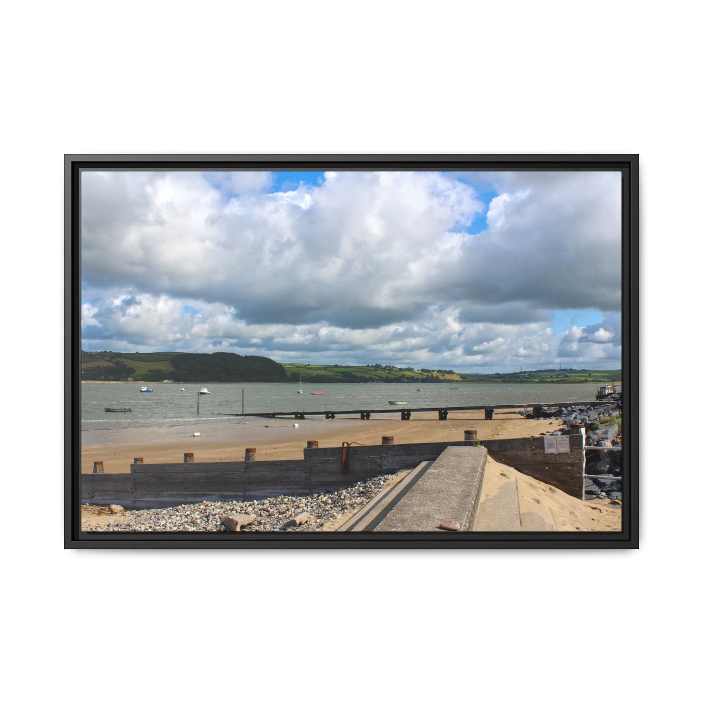 Framed photograph of a coastal scene with a bridge, beach, and cloudy sky.