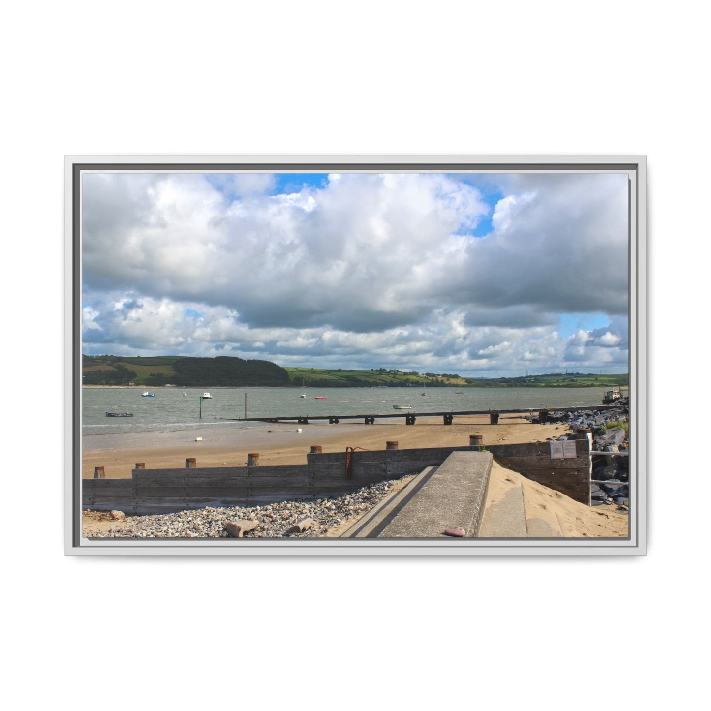Framed photograph of a coastal scene with a bridge, water, and clouds.
