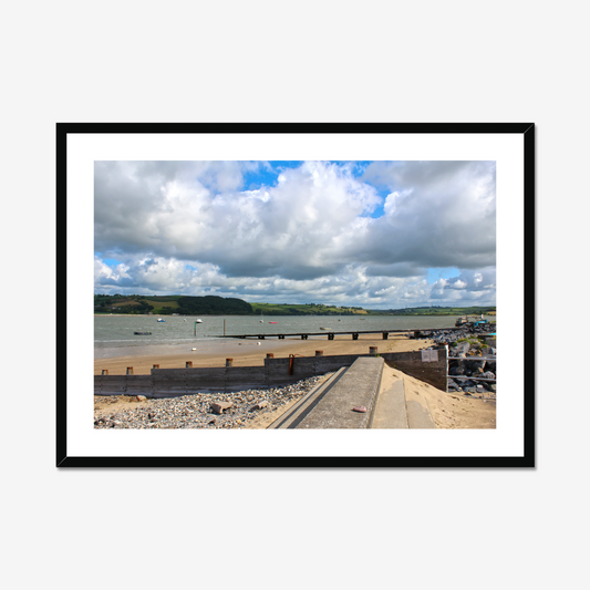 Framed photograph of a coastal scene with a dock and cloudy sky.