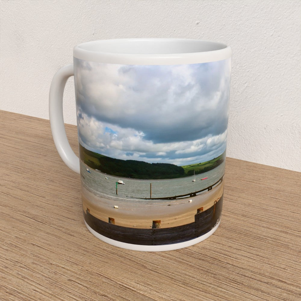 Mug with a scenic coastal view on a wooden surface