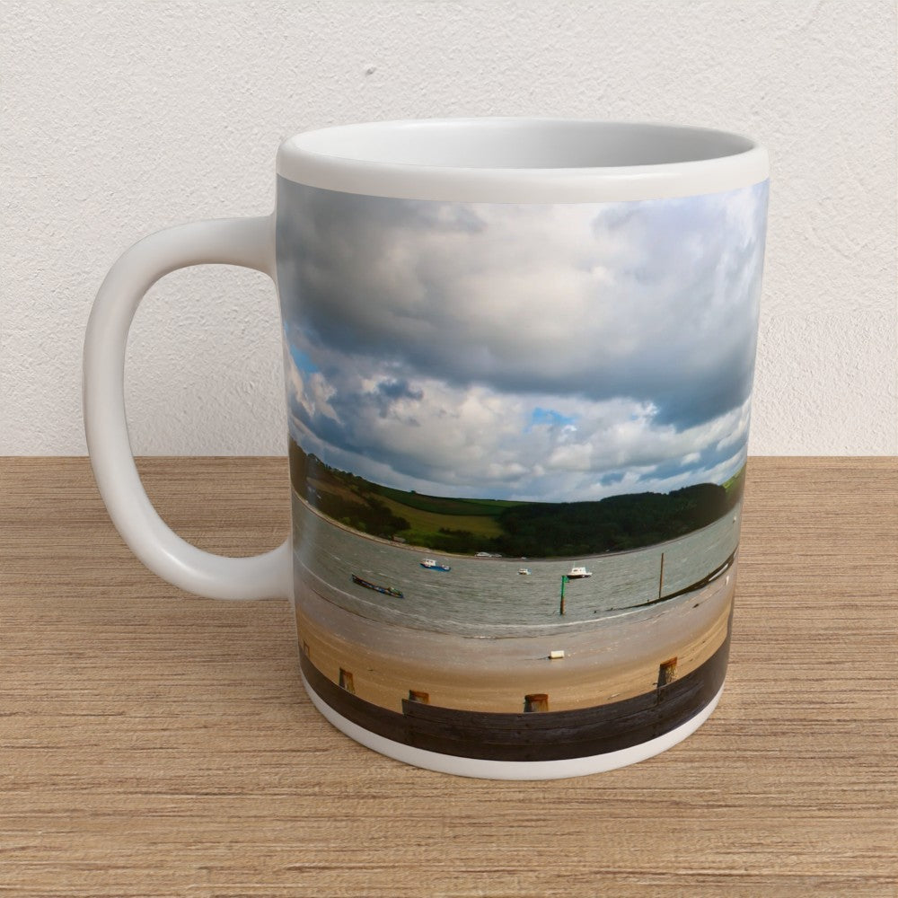Mug with a scenic coastal view on a wooden surface