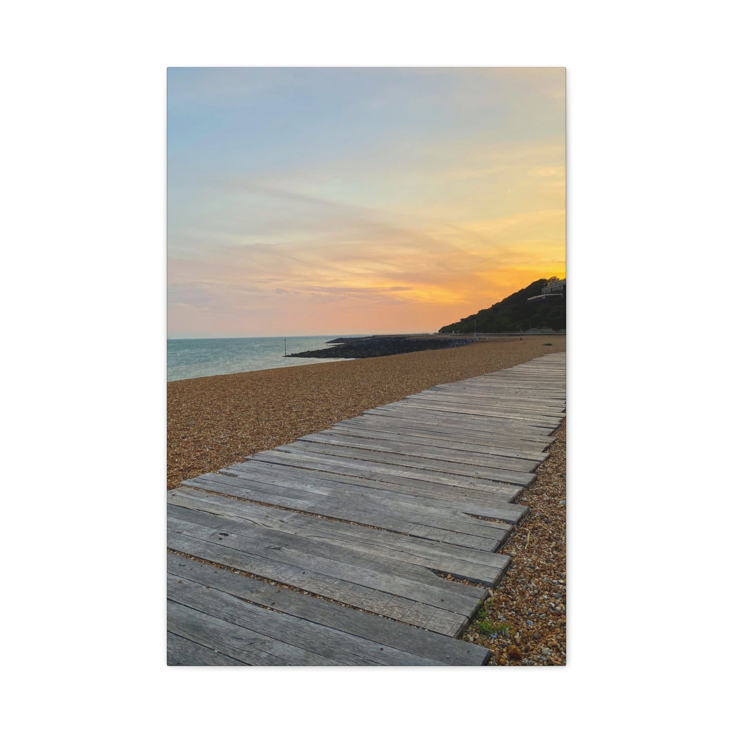 Wooden boardwalk leading to a beach with a colorful sunset sky.