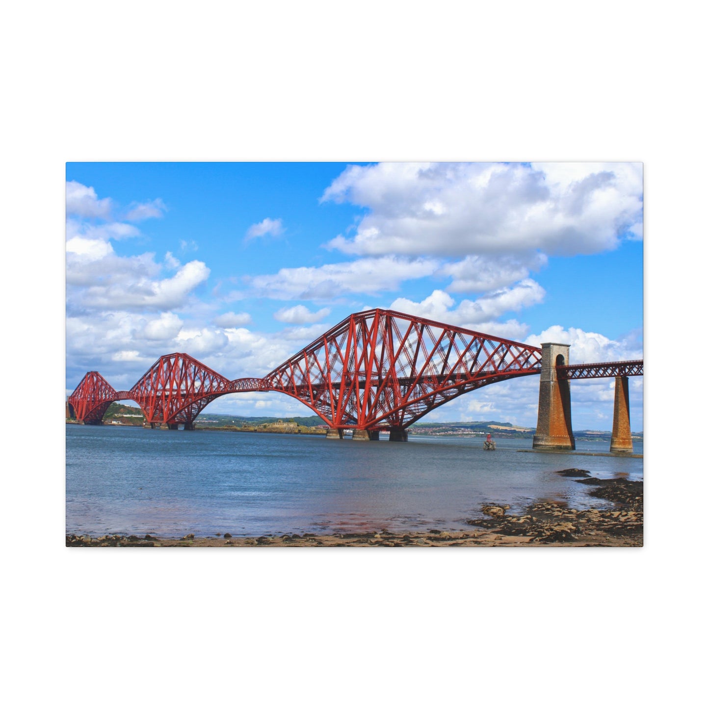 Red steel bridge over water with a blue sky and clouds