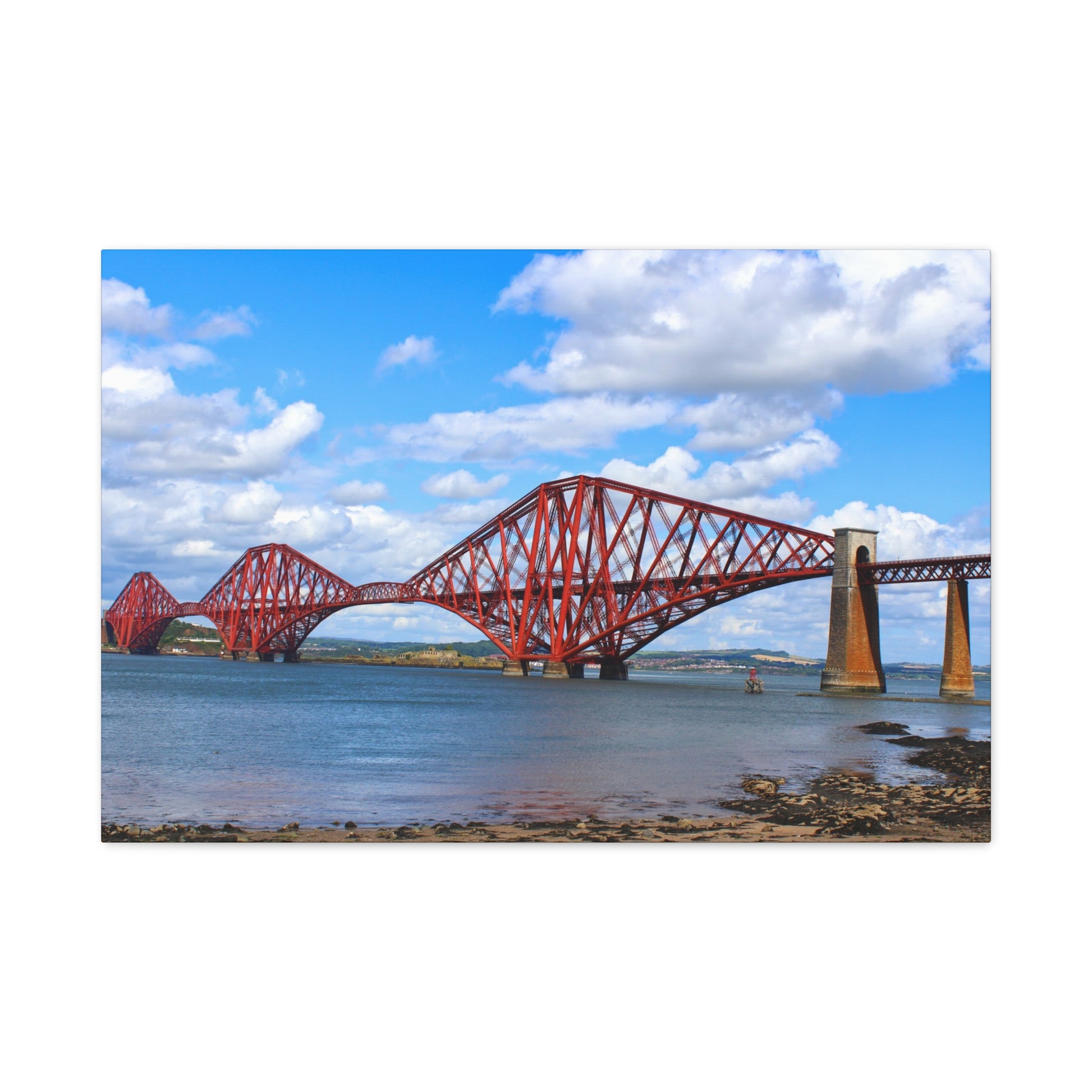 Red steel bridge over water with a blue sky and clouds