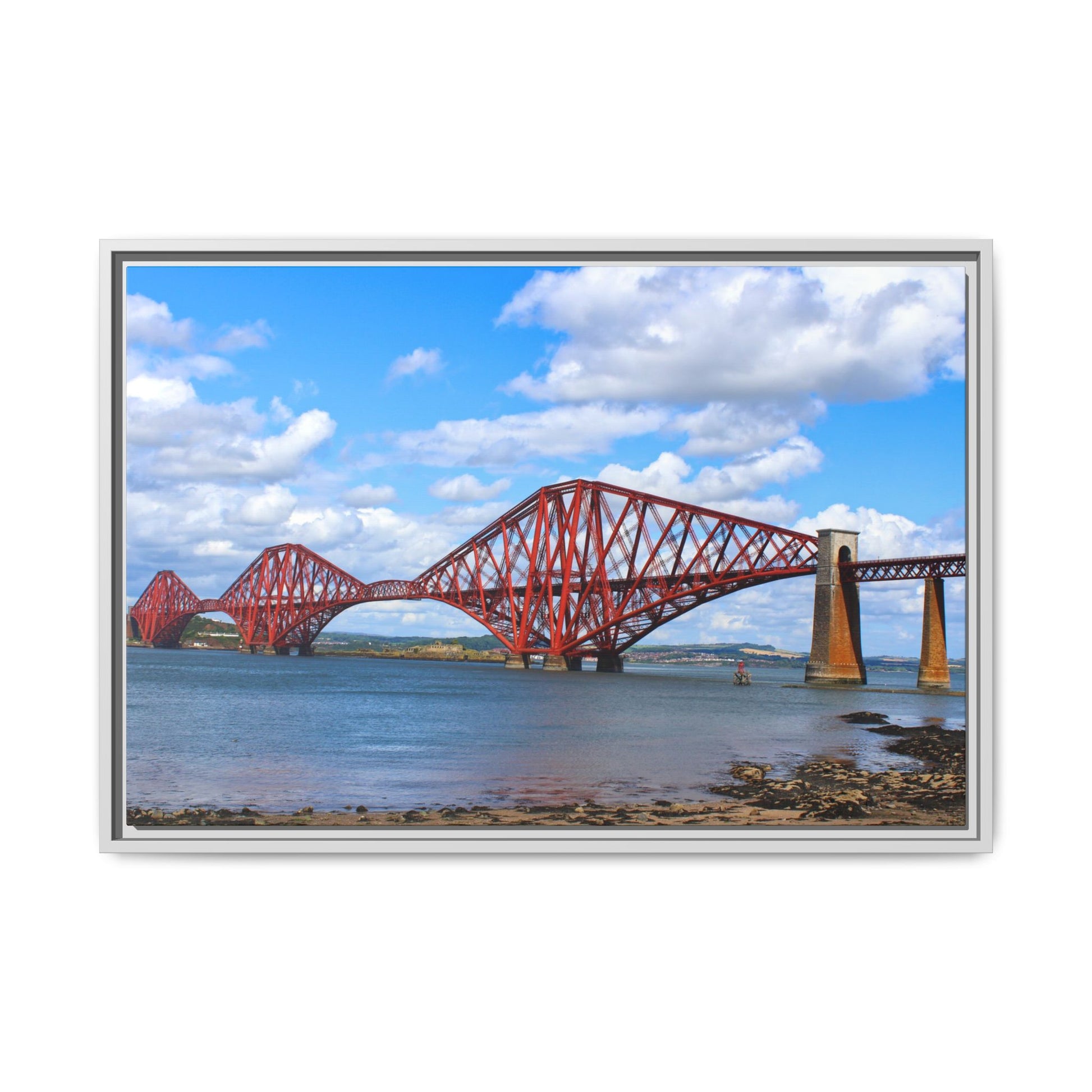 Red steel bridge over water with a blue sky and clouds