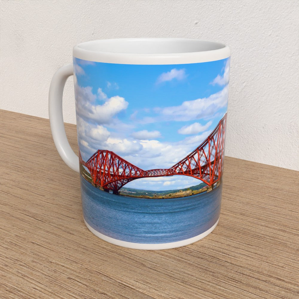Mug with a design of a red bridge and blue sky on a wooden surface.