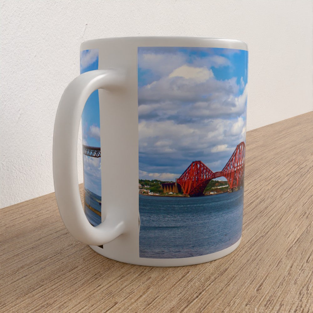 Mug with a scenic design of a red bridge and blue sky on a wooden surface.