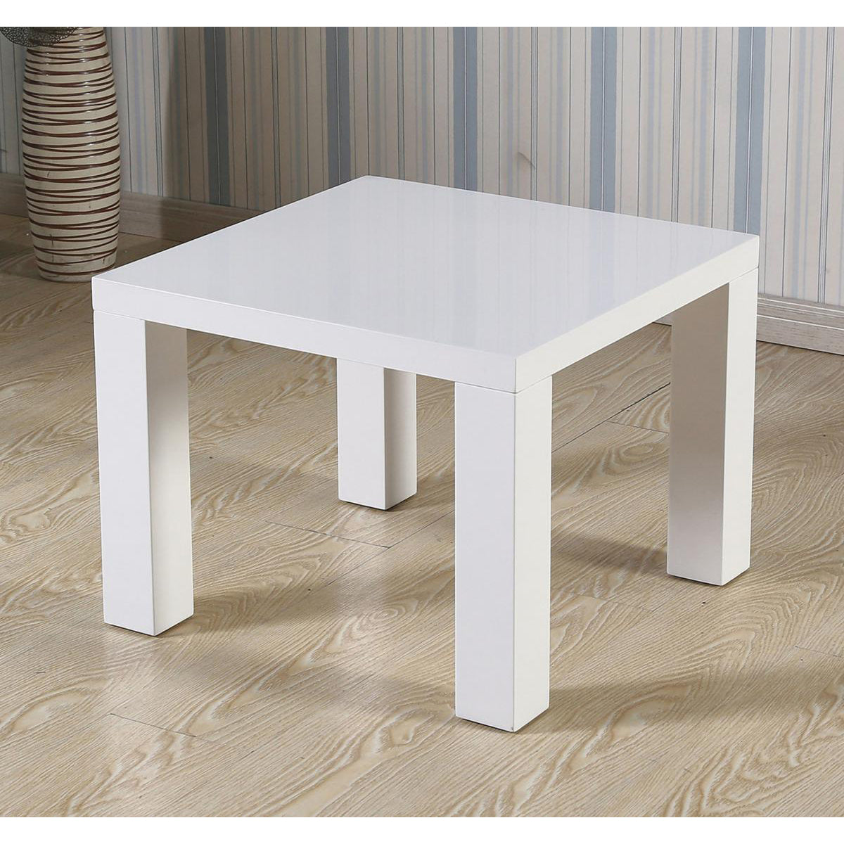 White square table on a wooden floor with striped wallpaper in the background
