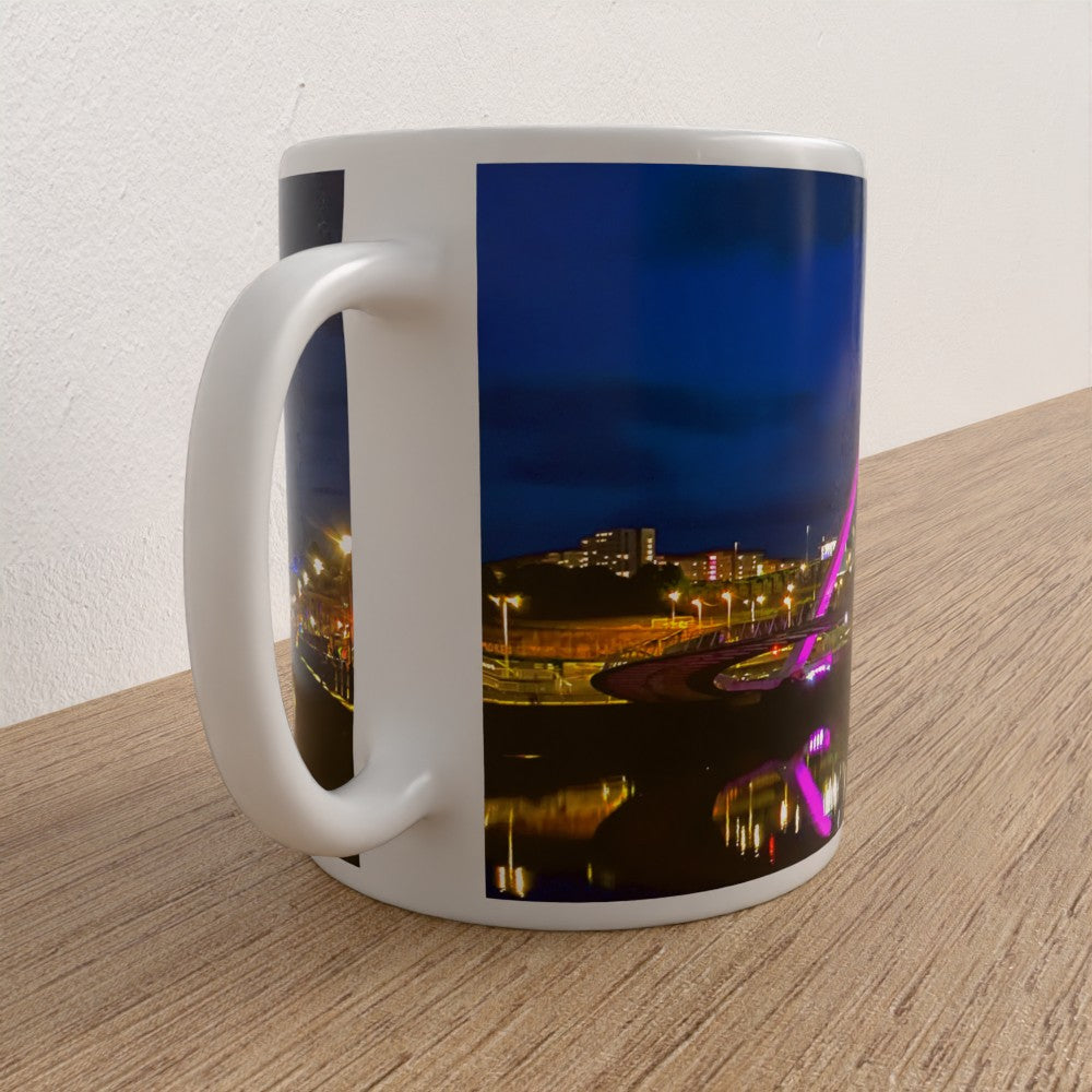 Mug with a scenic design of a cityscape at night on a wooden surface.