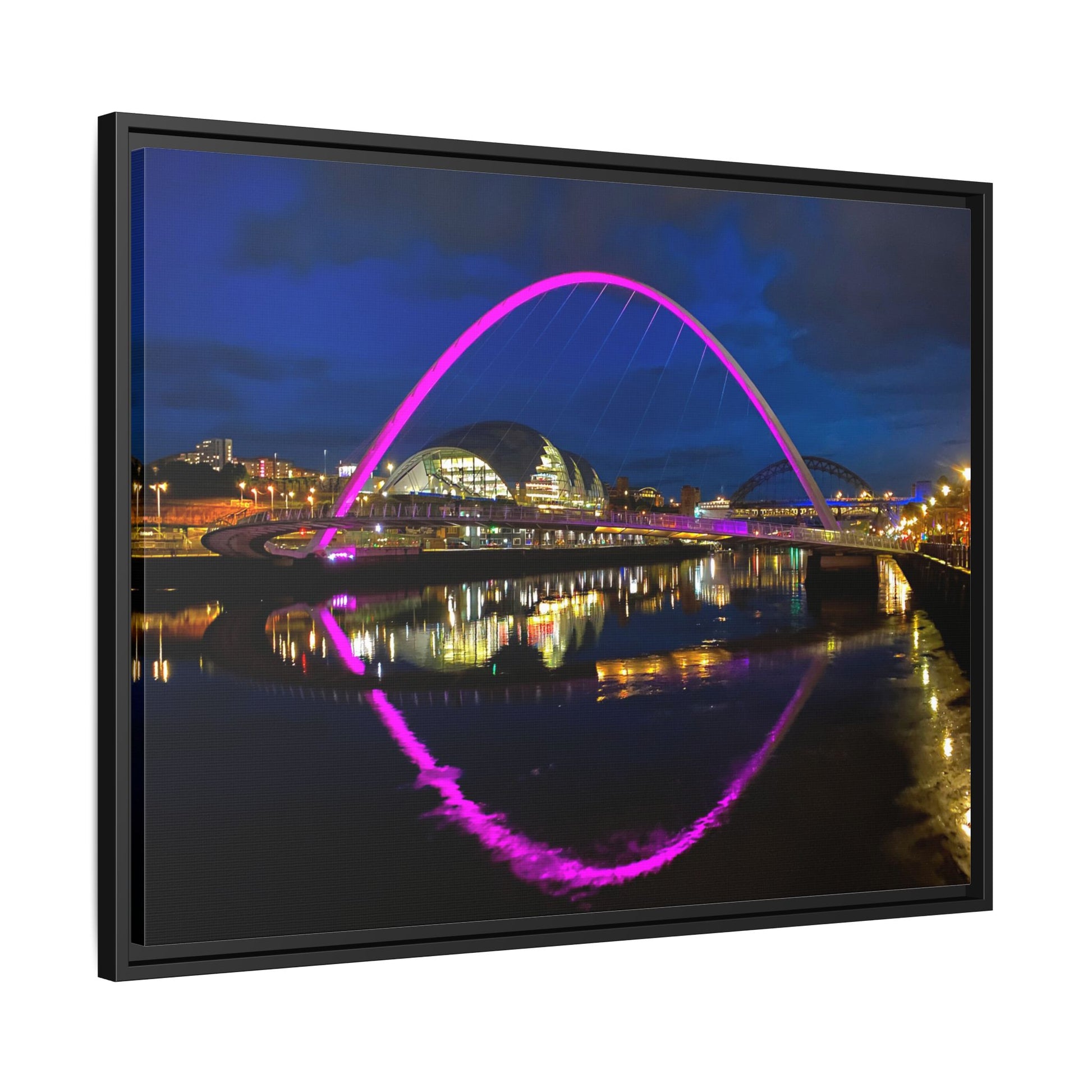 Framed artwork of a bridge with a colorful arch over water at night.