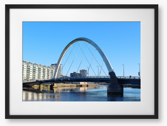 A framed photo of the Glasgow Clyde Arc Bridge over the River Clyde, with a clear blue sky in the background.