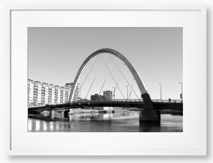 Black and White framed photo of the Glasgow Clyde Arc Bridge over the River Clyde, with a clear sky in the background.