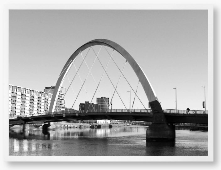 Black and White framed photo of the Glasgow Clyde Arc Bridge over the River Clyde, with a clear sky in the background.