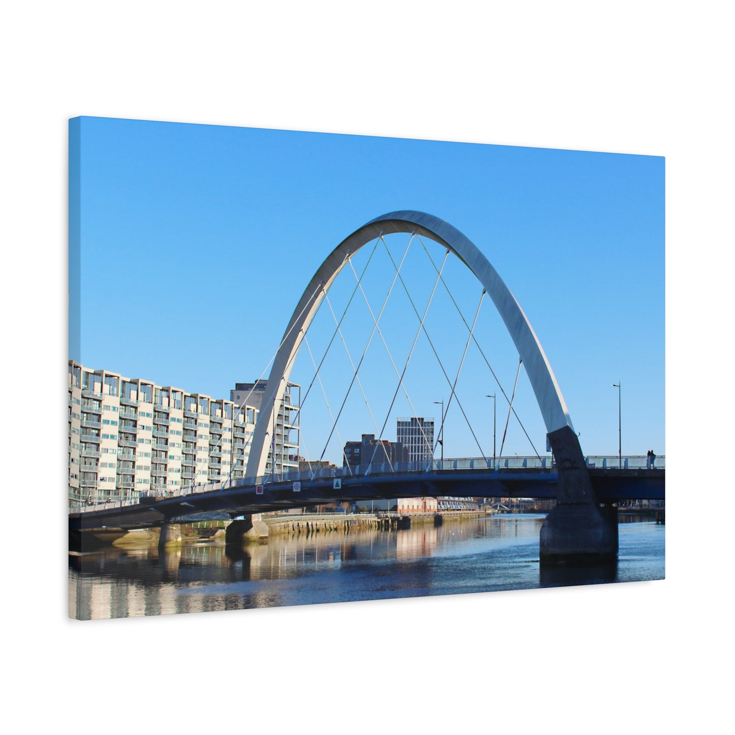 Arch bridge over a body of water with buildings in the background
