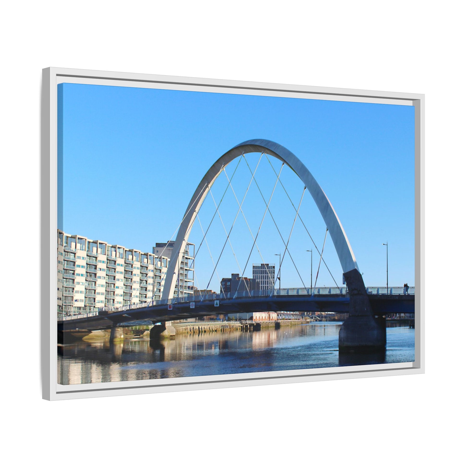 Framed picture of a bridge with a blue sky and buildings in the background
