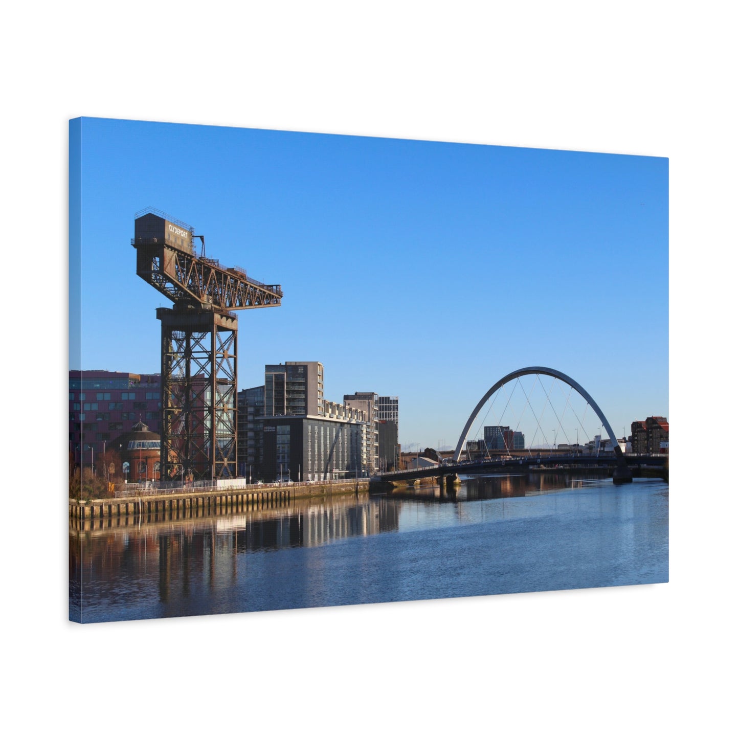 Cityscape with a crane and arch bridge reflected in water, clear blue sky