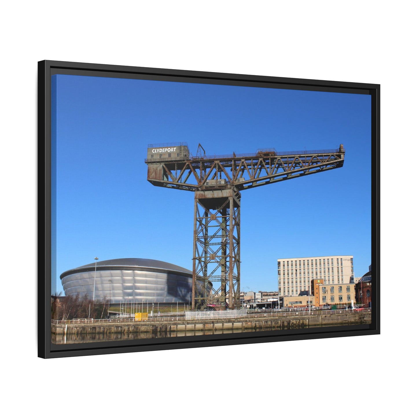 Framed photograph of a large industrial crane with a clear blue sky in the background.