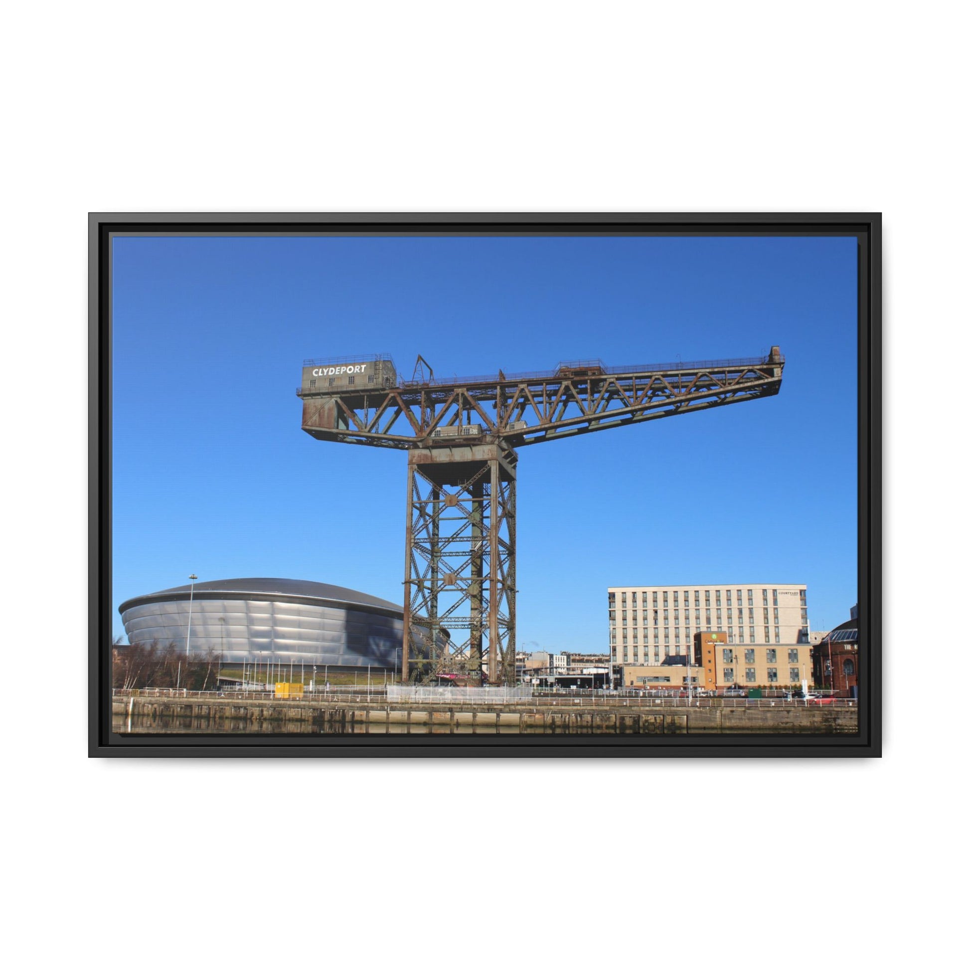 Framed photograph of a large crane with a blue sky background