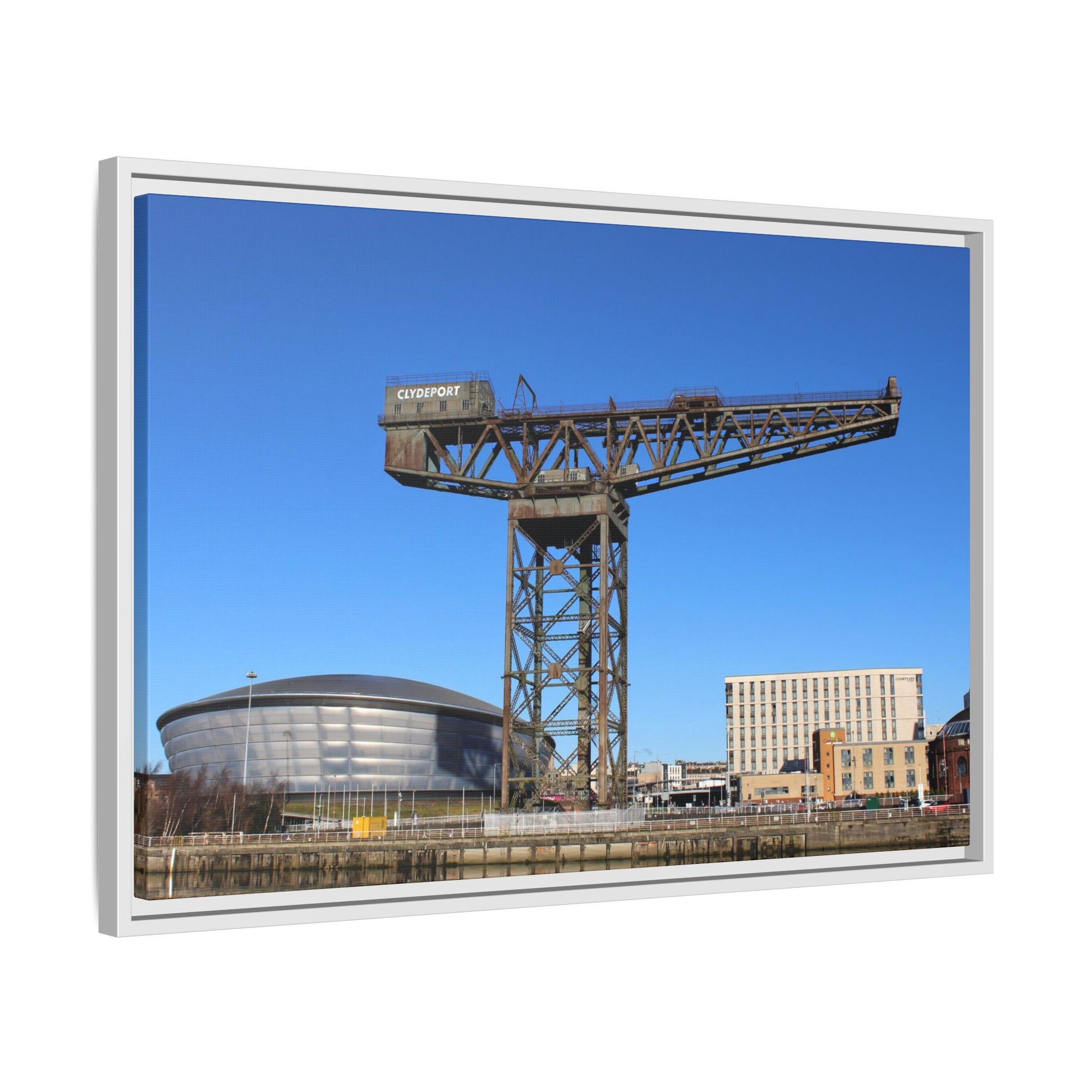 Framed photograph of a large industrial crane with a clear blue sky in the background.