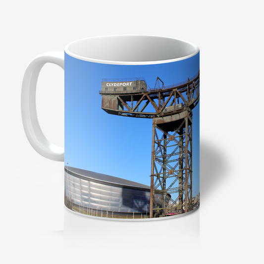 Mug with a printed design of a crane and building against a blue sky.