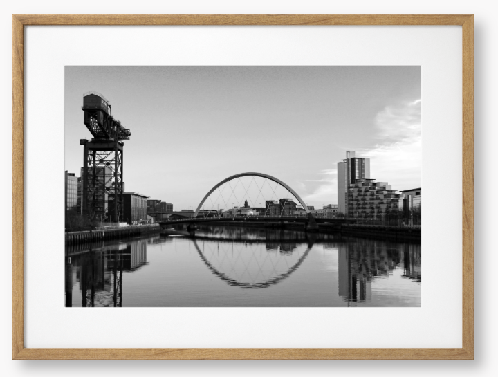 Black and White framed photograph of Glasgow's River Clyde with reflections, including a prominent crane and modern cityscape in the background.